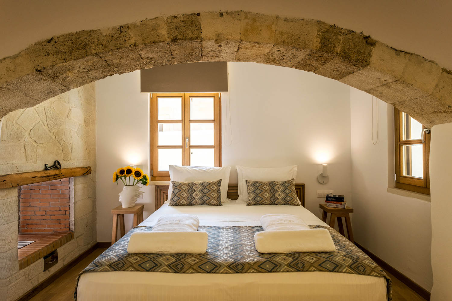 Hotel bedroom, a base with sunflowers at the side of the bed